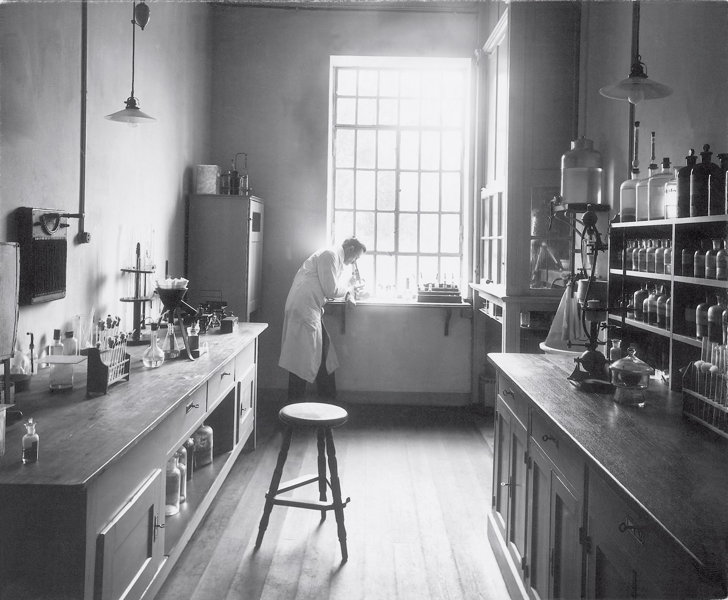 Imagem preto e branco de um laboratório com um cientista | Hartmann