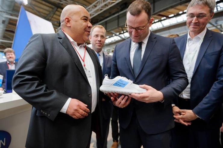 Chima Abuba handing over sport shoes to health minister Jens Spahn