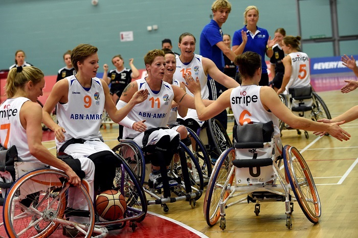Picture of the women wheelchair basketball team on the field.
