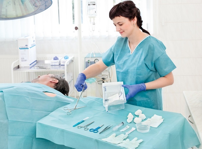 A female nurse preparing the instruments for a patient treatment.
