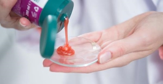 Close shot of a Kneipp product being dispensed on a glass.
