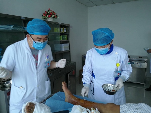 Huo Jizhen treating a patient’s wound together with a doctor. 