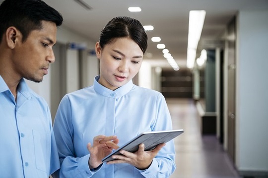 A female and male nurse working with a tablet.