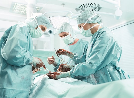 Emergency medical team operating patient on operation table.