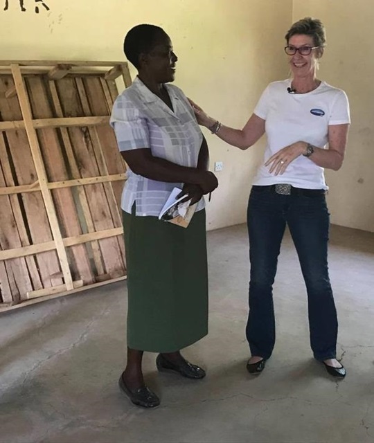 Niki Brandt and a woman of the Kisumu community are chatting and laughing.