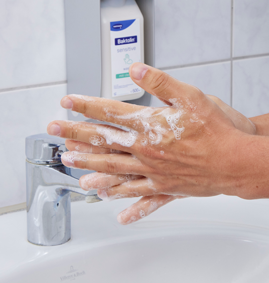 A person washing hands with Baktolin sensitive in the background