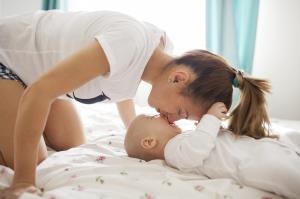 A young mother kisses her baby