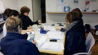 Nurses sitting around a table discussing paperwork