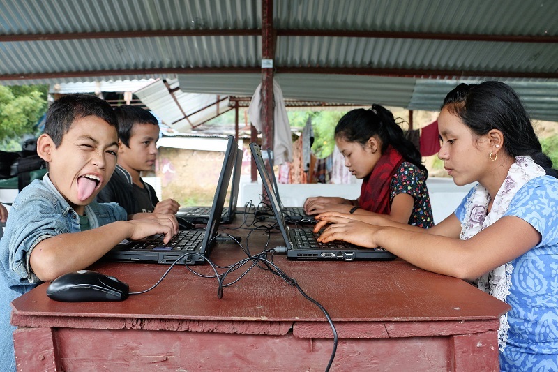 Nepalese students sitting in front of computers at class.