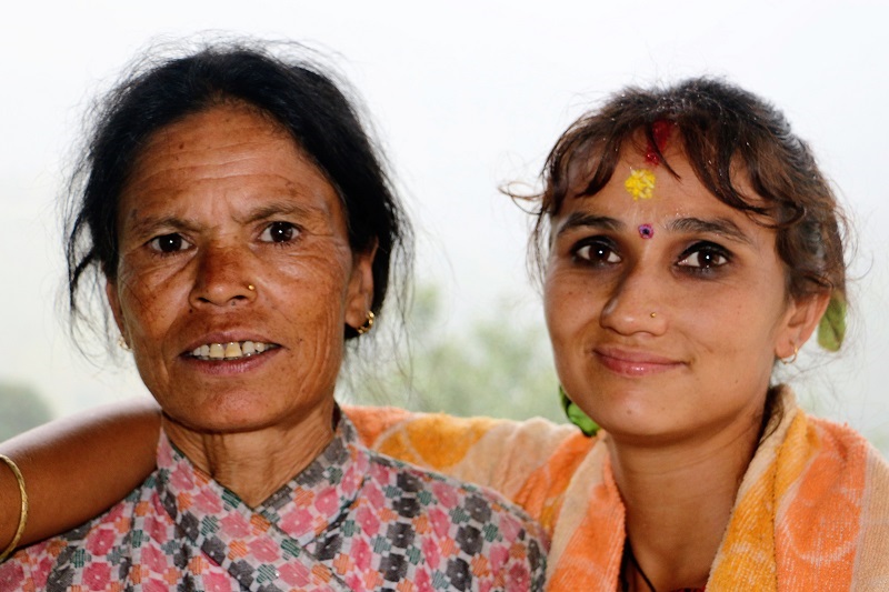 Two Nepalese woman smiling into the camera.