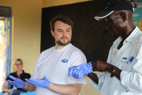 Jan Schröder training healthcare worker on the use of hygiene gloves.
