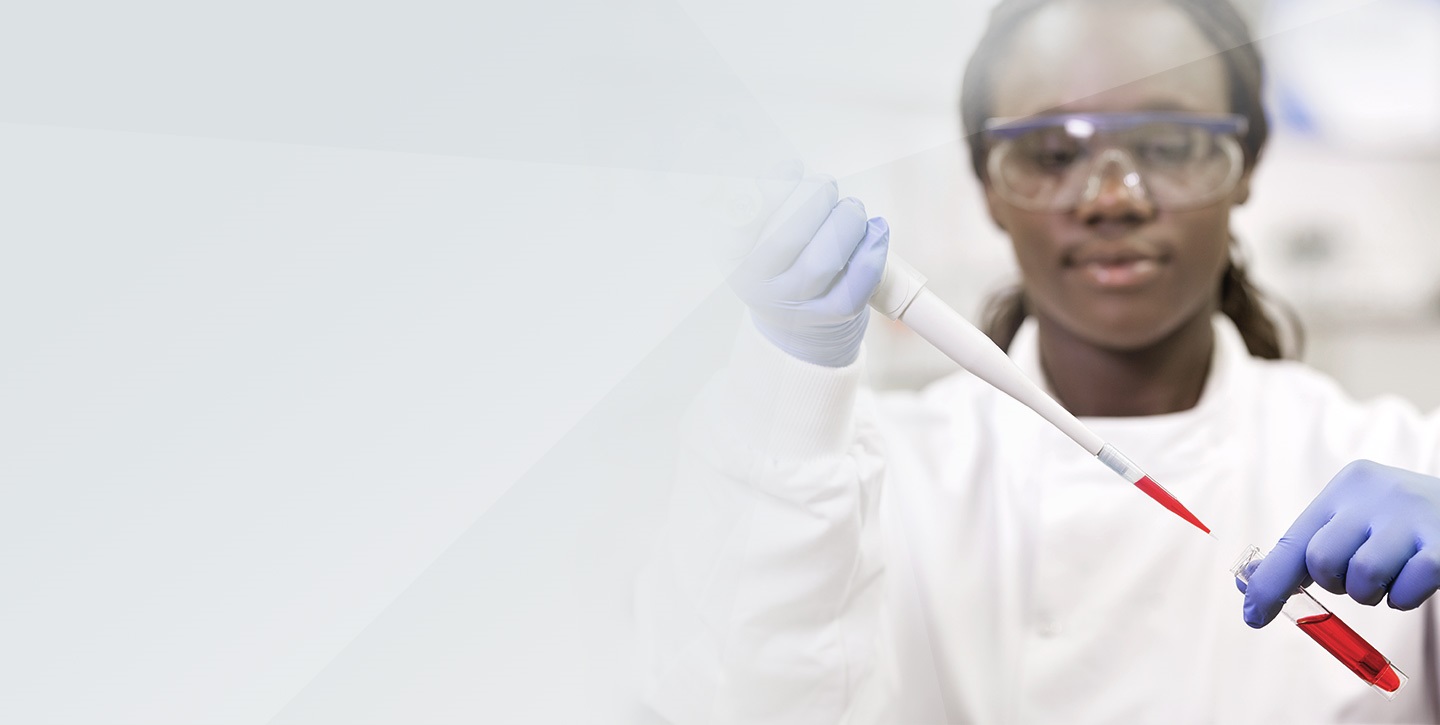 Female lab professional using pipette. 