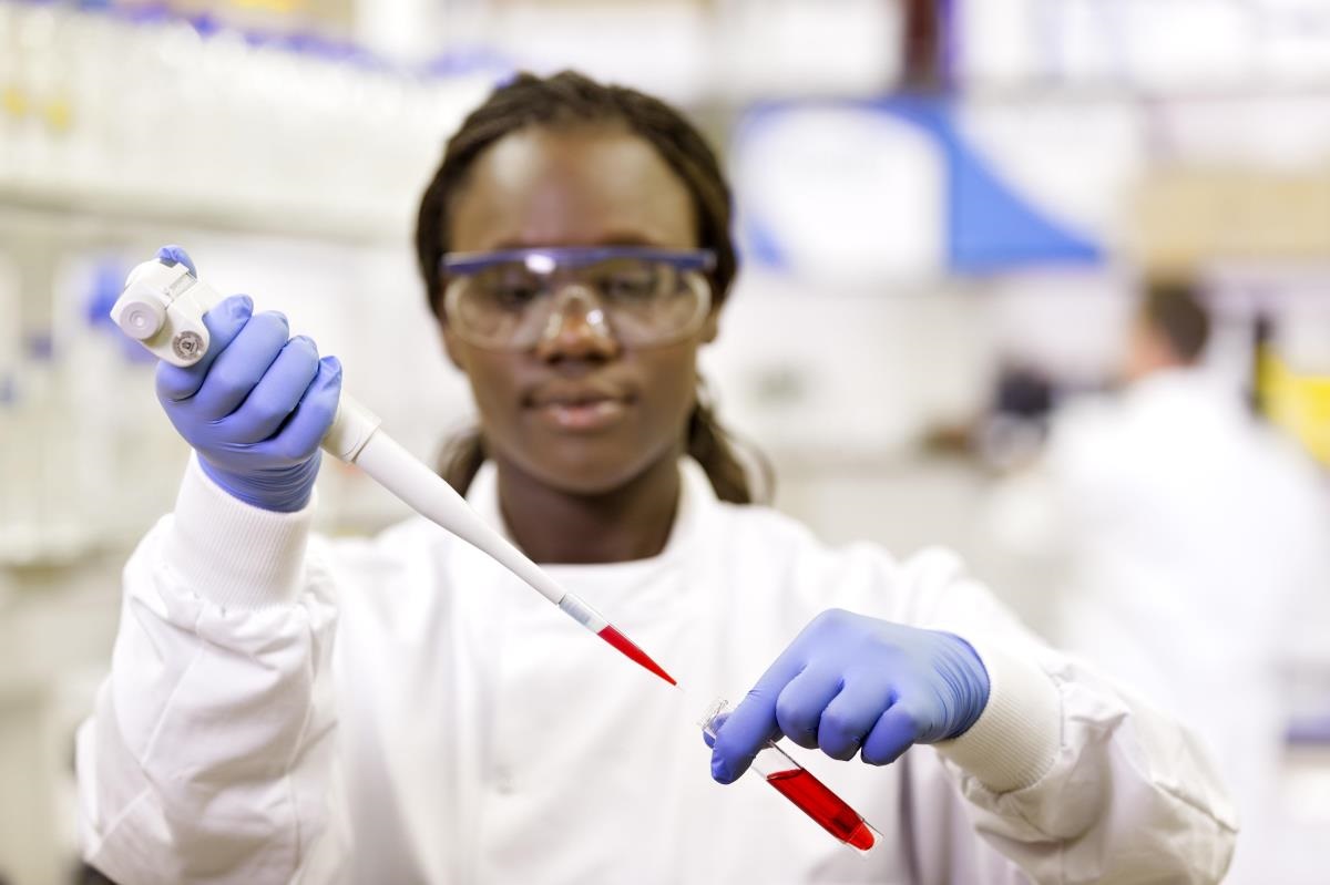 Female lab professional using pipette.