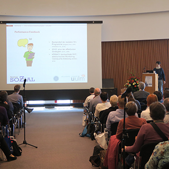 Tagungsraum Ulmer Symsposium 2019 mit Teilnehmern von hinten und Referentin