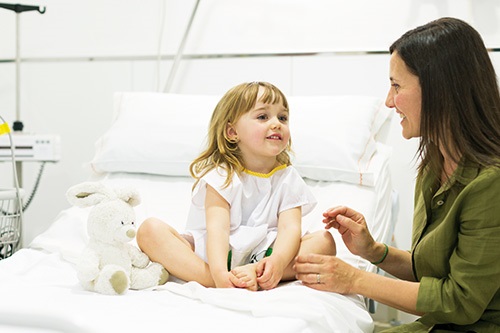 Madre e hija soriendo en una habitación de hospital