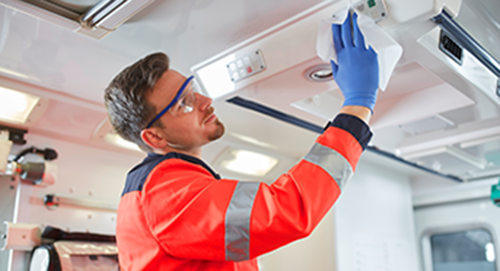 RettungssanitÀter desinfiziert das innere eines Rettungswagens mit einem Desinfektionstuch.