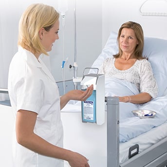 Krankenhaus - Schwester bei Händedesinfektion am Bett einer Patientin