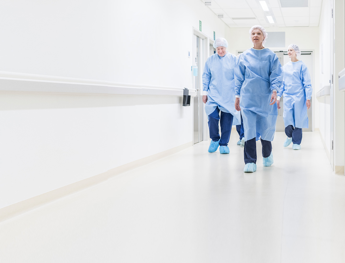 Doctors in personal protective equipment walking down a hospital hallway