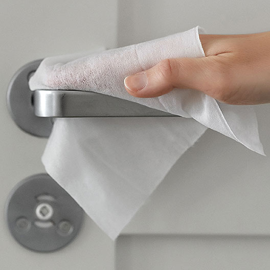 Foto von der Anwendung von Sterillium 2in1 Wipes zur Desinfektion einer Türschnalle.