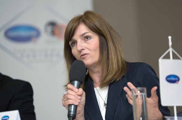MUDr. Mgr. Jolana Těšinová, Ph.D. na přednášce s mikrofonem v ruce