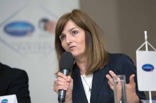 MUDr. Mgr. Jolana Těšinová, Ph.D. na přednášce s mikrofonem v ruce