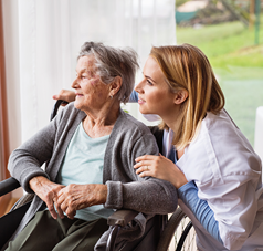 Pflegerin und Seniorin im Rollstuhl