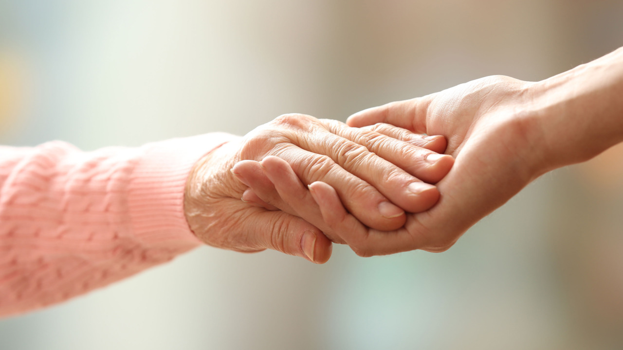 Alte Hand greift nach junger Hand