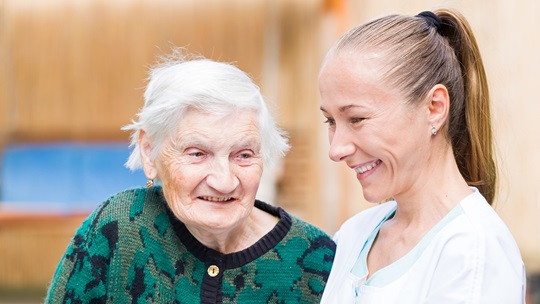 lachende Seniorin und Pflegerin