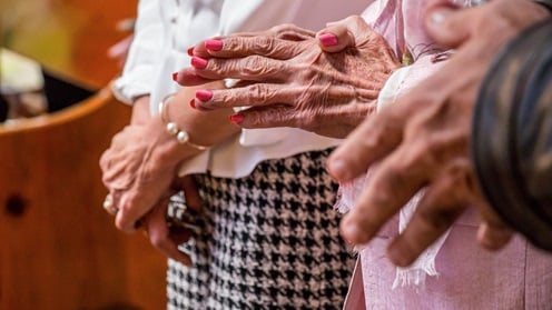 gefaltene Hände von Senioren vor der Körpermitte