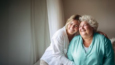 jungere Frau umarmt Seniorin