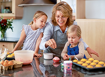 Großmutter mit Enkelkindern beim Backen