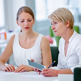zwei weiß gekleidete Frauen besprechen sich