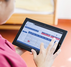 Frau tippt auf Tablet - HILMAS