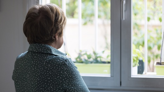 Frau schaut aus dem Fenster