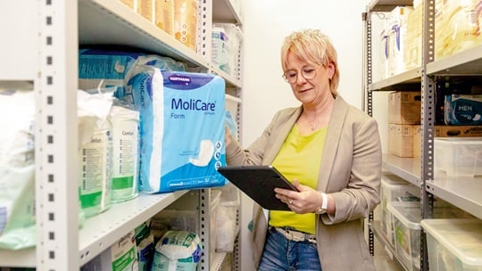 Nadine Schnell nimmt MoliCare Packung aus dem Lagerregal