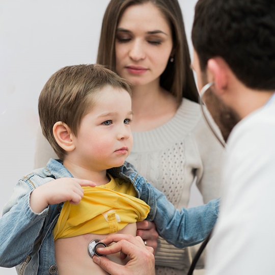 Arzt untersucht Baby im Gesundheitskiosk