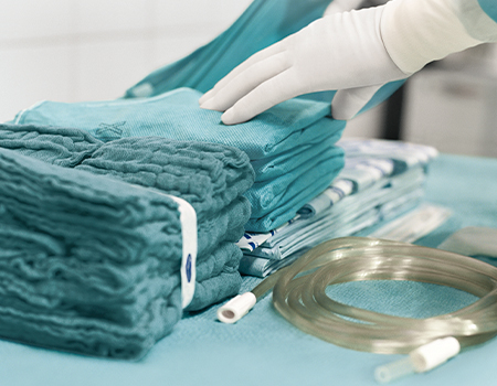 Manos de cirujano preparando los materiales para una operación - HARTMANN