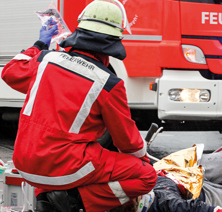 Rettungssanitäter an Unfallstelle hält Infusion hoch
