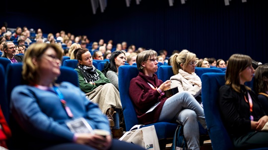 Publikum im Kinosaal hört den Vorträgen zu