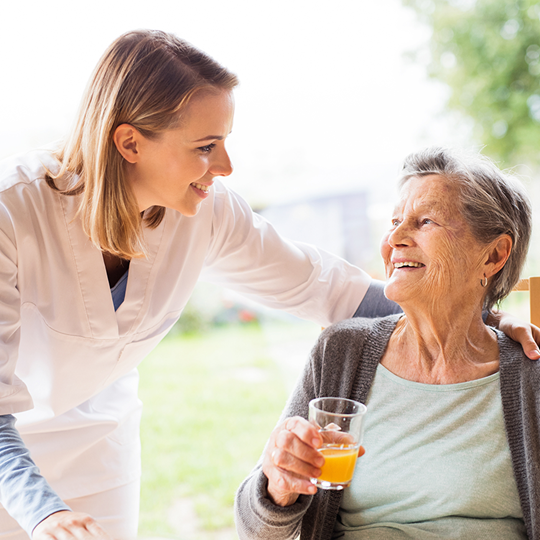 Pflegerin mit Seniorin im Gespräch