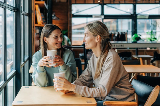 zwei Frauen unterhalten sich im Cafe