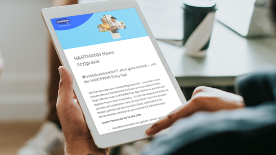 Hand hält ein Tablet auf dem der Newsletter des Wundforums abgebildet ist