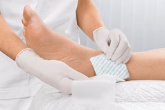 Hydroclean Wundauflage wird an Knöchel angebracht