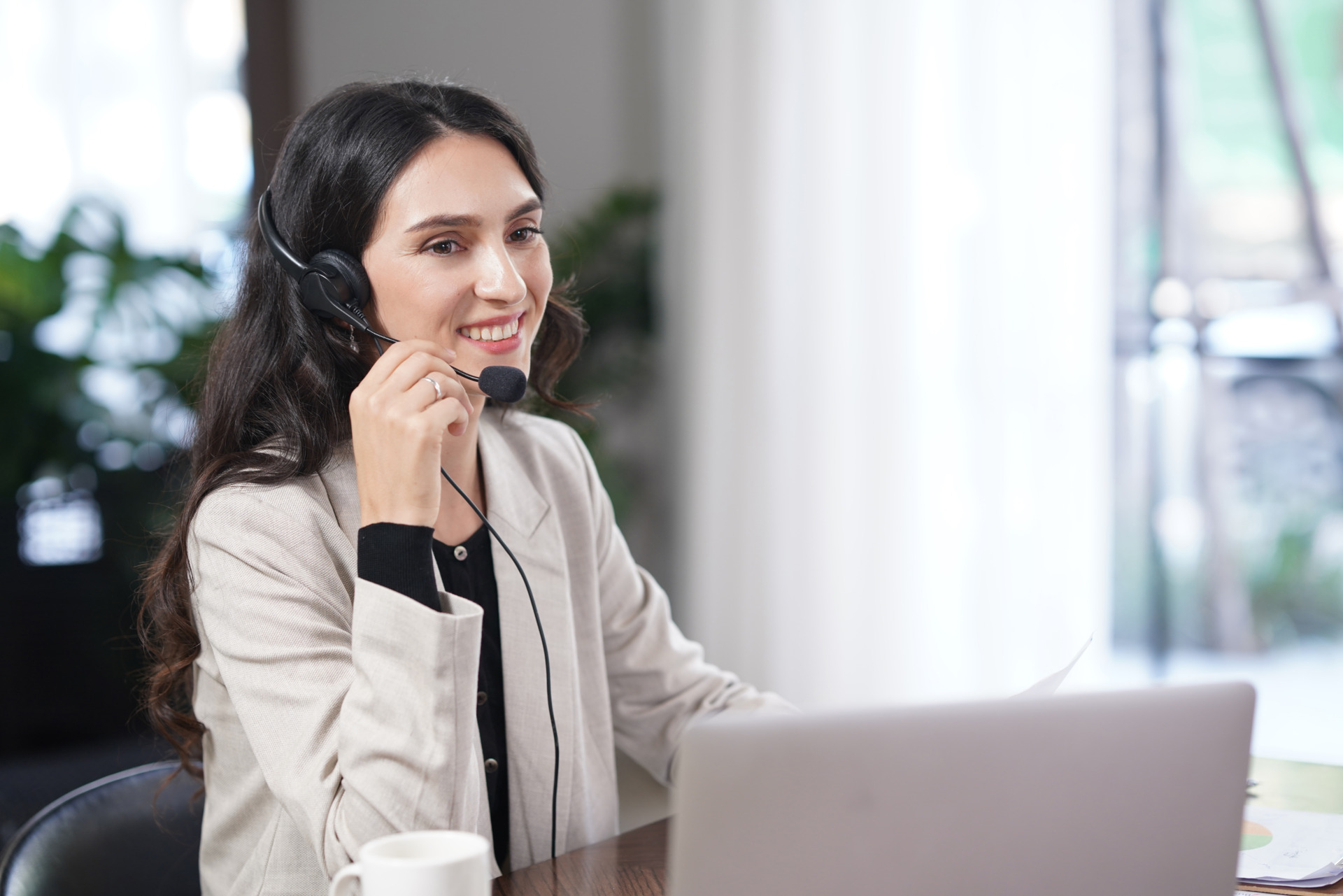 Frau mit Headset im Callcenter vor einem Notebook