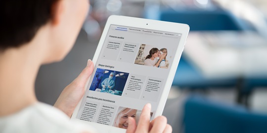 Mujer mirando el catálogo de productos sanitarios de HARTMANN desde un ipad - HARTMANN