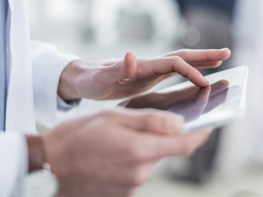 Arzt gibt Daten in ein Tablet ein