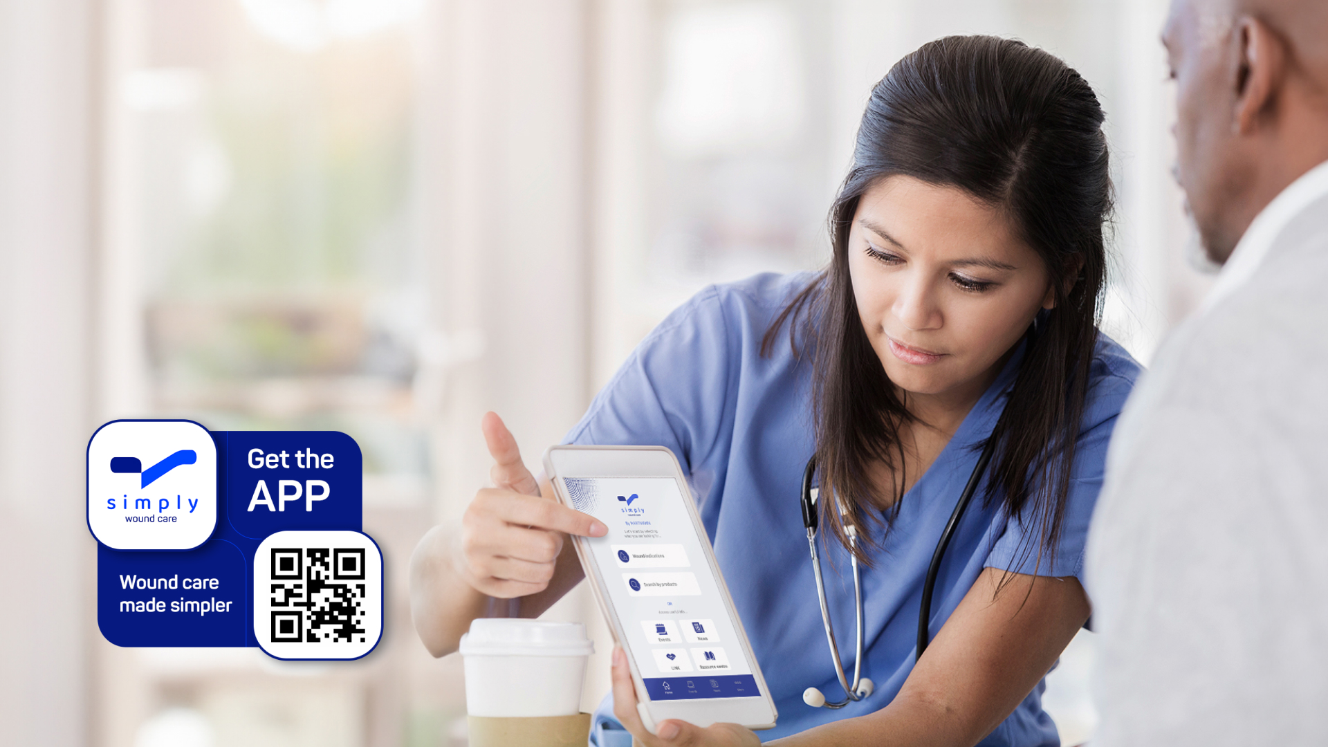 A nurse looks at a tablet showing the user interface of the Simply app.