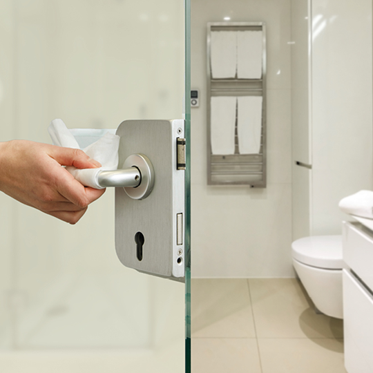 geöffnete Badtüre mit Bad und Toilette im Hintergrund