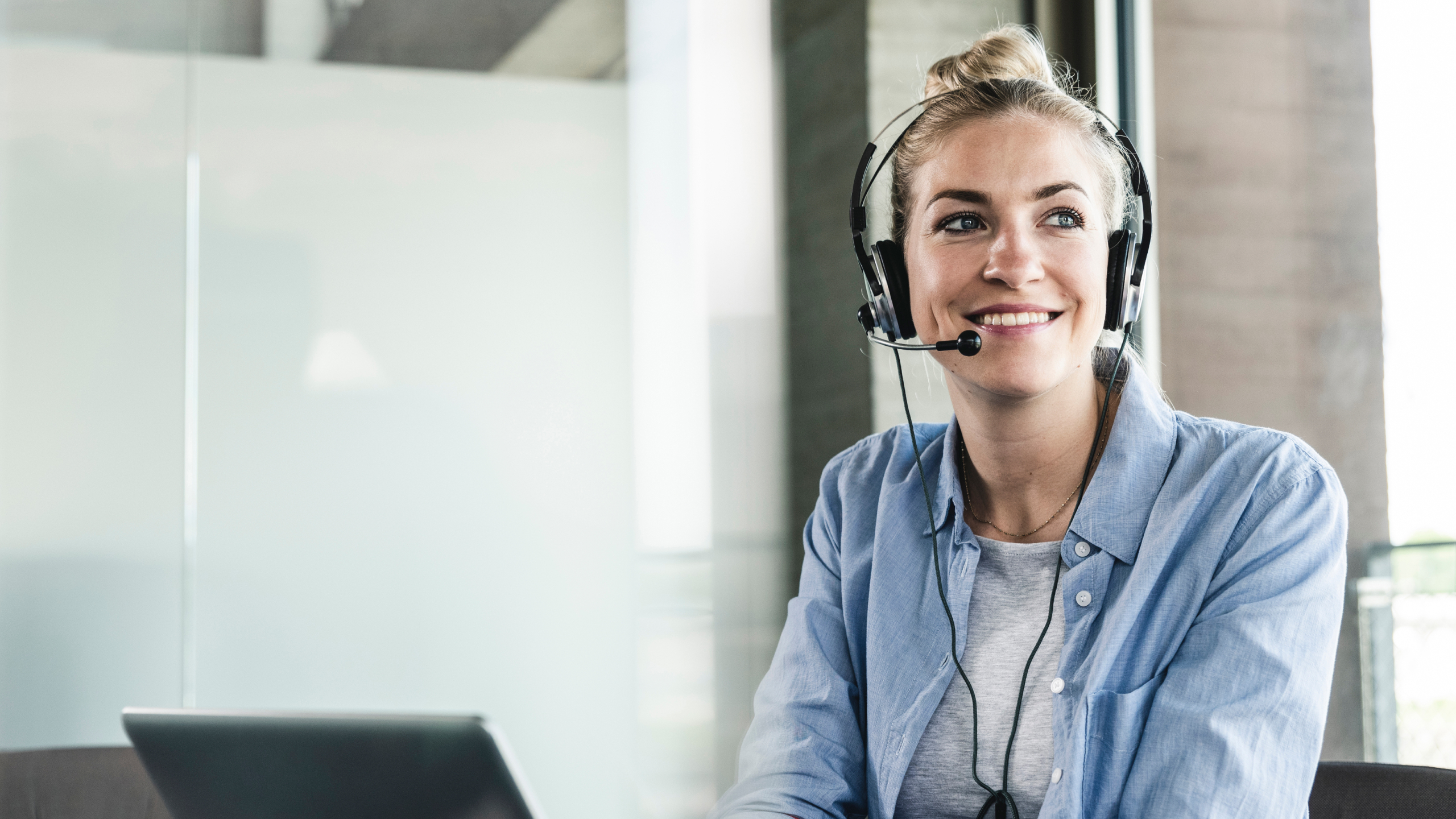 Eine junge Frau sitzt an ihrem Laptop.