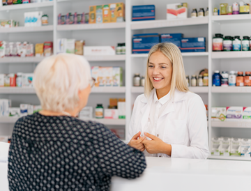 Young female pharmacist advising female senior in a pharmacy